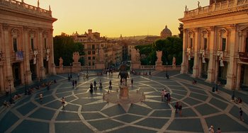 Movie still from “To Rome with Love” (2012), directed by Woody Allen – A group of people gathered around a statue in the middle of a circle; Extreme Wide shot, High angle