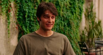 Movie still from “To Rome with Love” (2012), directed by Woody Allen – A young man standing in front of a wall covered in ivy; Close Up shot, Over the shoulder angle