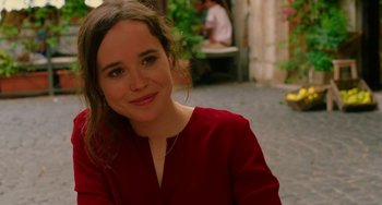 Movie still from “To Rome with Love” (2012), directed by Woody Allen – A woman in a red shirt is smiling for the camera; Close Up shot, Over the shoulder angle