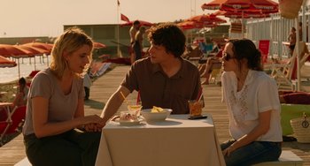 Movie still from “To Rome with Love” (2012), directed by Woody Allen – Three people sitting at a table with a bowl of food; Medium shot, Over the shoulder angle