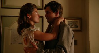 Movie still from “To Rome with Love” (2012), directed by Woody Allen – A man and a woman embracing each other in front of a wall; Medium shot, Low angle