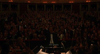 Movie still from “To Rome with Love” (2012), directed by Woody Allen – A crowd of people in a theater with a conductor in front of them; Extreme Wide shot, High angle