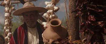Movie still from “Tombstone” (1993), directed by George P. Cosmatos – A man standing next to a bunch of garlic bulbs; Close Up shot, Low angle
