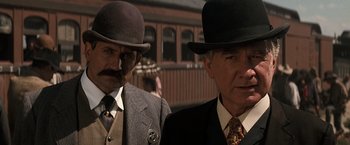 Movie still from “Tombstone” (1993), directed by George P. Cosmatos – A couple of men in suits and hats standing next to each other; Close Up shot, Low angle