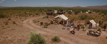 Movie still from “Tombstone” (1993), directed by George P. Cosmatos – A group of people standing in the middle of the desert; Extreme Wide shot, High angle