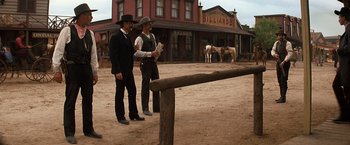 Movie still from “Tombstone” (1993), directed by George P. Cosmatos – A couple of men standing next to each other on a dirt field; Wide shot, Over the shoulder angle