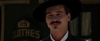 Movie still from “Tombstone” (1993), directed by George P. Cosmatos – A man in a suit and a hat with a mustache; Close Up shot, Low angle