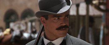 Movie still from “Tombstone” (1993), directed by George P. Cosmatos – A person wearing a hat and holding an umbrella; Close Up shot, Low angle