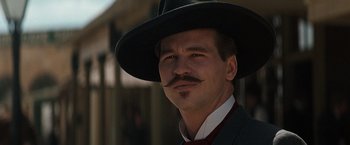 Movie still from “Tombstone” (1993), directed by George P. Cosmatos – A man with a mustache wearing a hat and a suit; Close Up shot, Low angle
