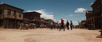 Movie still from “Tombstone” (1993), directed by George P. Cosmatos – A group of people in a dirt field with horses; Extreme Wide shot, Low angle