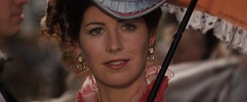 Movie still from “Tombstone” (1993), directed by George P. Cosmatos – A person wearing a hat and holding an umbrella; Close Up shot, Over the shoulder angle