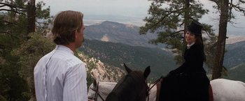 Movie still from “Tombstone” (1993), directed by George P. Cosmatos – A man riding a horse on top of a mountain; Wide shot, Over the shoulder angle