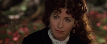 Movie still from “Tombstone” (1993), directed by George P. Cosmatos – A person with curly hair wearing a black jacket; Close Up shot, Over the shoulder angle