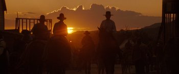 Movie still from “Tombstone” (1993), directed by George P. Cosmatos – A group of people riding horses at sunset; Wide shot, Low angle