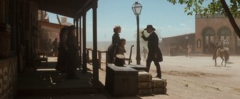 Movie still from “Tombstone” (1993), directed by George P. Cosmatos – A group of people standing on the side of the street; Wide shot, Low angle