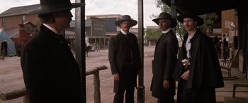 Movie still from “Tombstone” (1993), directed by George P. Cosmatos – A couple of men standing next to each other on a dirt road; Wide shot, Low angle