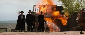 Movie still from “Tombstone” (1993), directed by George P. Cosmatos – A group of men standing in front of a burning building; Wide shot, Low angle