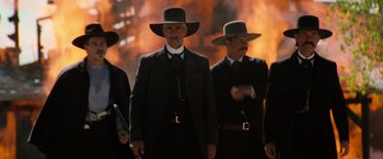 Movie still from “Tombstone” (1993), directed by George P. Cosmatos – A group of men in suits and hats standing next to each other; Medium shot, Low angle