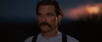 Movie still from “Tombstone” (1993), directed by George P. Cosmatos – A man with long hair and a mustache wearing suspenders; Close Up shot, Low angle