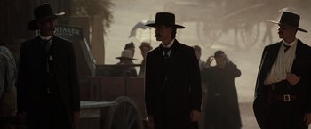 Movie still from “Tombstone” (1993), directed by George P. Cosmatos – A man in a black suit and a black hat; Medium shot, Low angle