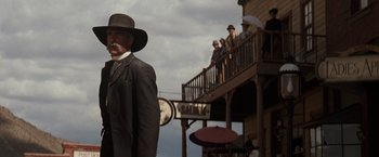 Movie still from “Tombstone” (1993), directed by George P. Cosmatos – A group of people standing on a porch of a building; Medium shot, Low angle