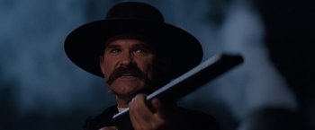 Movie still from “Tombstone” (1993), directed by George P. Cosmatos – A person holding a baseball bat; Close Up shot, Low angle
