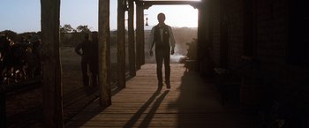 Movie still from “Tombstone” (1993), directed by George P. Cosmatos – A man is walking down a wooden walkway; Wide shot, Low angle