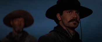 Movie still from “Tombstone” (1993), directed by George P. Cosmatos – A man with a mustache wearing a black hat; Close Up shot, Low angle