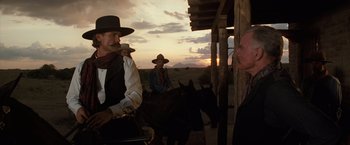 Movie still from “Tombstone” (1993), directed by George P. Cosmatos – A group of men riding horses on a dirt road; Medium shot, Low angle