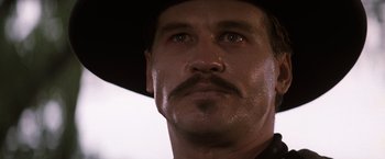 Movie still from “Tombstone” (1993), directed by George P. Cosmatos – A person wearing a cowboy hat; Close Up shot, Low angle