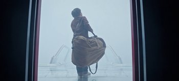 Movie still from “Tomorrowland” (2015), directed by Brad Bird – A young boy is holding a large duffel bag; Wide shot, Low angle