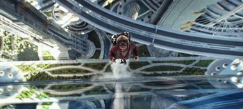 Movie still from “Tomorrowland” (2015), directed by Brad Bird – A dog flying through the air on top of a building; Wide shot, Overhead angle
