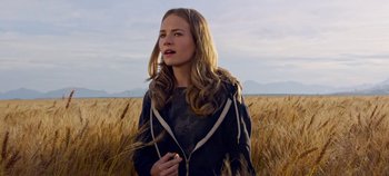 Movie still from “Tomorrowland” (2015), directed by Brad Bird – A beautiful young lady standing in the middle of a field; Medium shot, Low angle