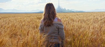 Movie still from “Tomorrowland” (2015), directed by Brad Bird – A woman standing in a wheat field looking at a city; Medium shot, Low angle