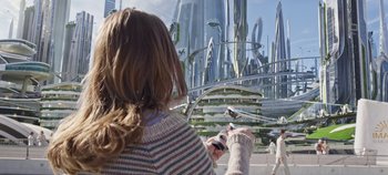 Movie still from “Tomorrowland” (2015), directed by Brad Bird – A woman holding a cell phone in her hands; Wide shot, Over the shoulder angle