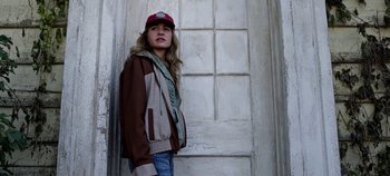 Movie still from “Tomorrowland” (2015), directed by Brad Bird – A woman standing in front of a door wearing a hat; Medium shot, Low angle