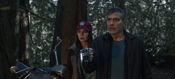Movie still from “Tomorrowland” (2015), directed by Brad Bird – A man and a woman standing next to each other in the woods; Medium shot, Low angle