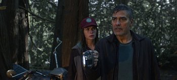Movie still from “Tomorrowland” (2015), directed by Brad Bird – A man and a woman standing next to each other in the woods; Medium shot, Low angle