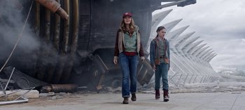 Movie still from “Tomorrowland” (2015), directed by Brad Bird – Two people walking on a street near a train; Medium shot, Low angle
