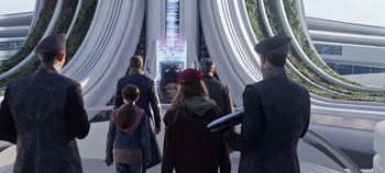 Movie still from “Tomorrowland” (2015), directed by Brad Bird – A group of people walking in front of a building; Wide shot, Over the shoulder angle