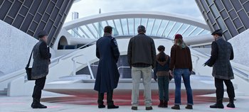 Movie still from “Tomorrowland” (2015), directed by Brad Bird – A group of people standing in front of a building; Wide shot, Low angle