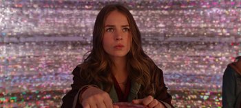 Movie still from “Tomorrowland” (2015), directed by Brad Bird – A woman with long brown hair sitting in front of a wall; Close Up shot, Low angle