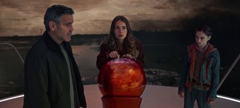 Movie still from “Tomorrowland” (2015), directed by Brad Bird – A man and a woman standing next to an apple; Medium shot, High angle