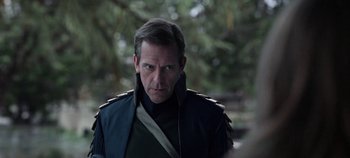 Movie still from “Tomorrowland” (2015), directed by Brad Bird – A person wearing a jacket with trees in the background; Close Up shot, Over the shoulder angle