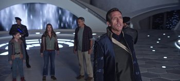 Movie still from “Tomorrowland” (2015), directed by Brad Bird – A group of people standing in a room; Medium shot, Over the shoulder angle