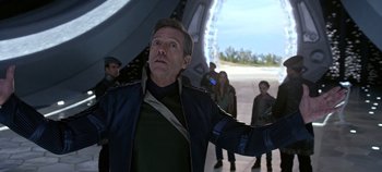 Movie still from “Tomorrowland” (2015), directed by Brad Bird – A man standing in front of a group of people; Medium shot, Over the shoulder angle