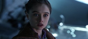 Movie still from “Tomorrowland” (2015), directed by Brad Bird – A young girl stares into the distance with a surprised look; Close Up shot, Over the shoulder angle
