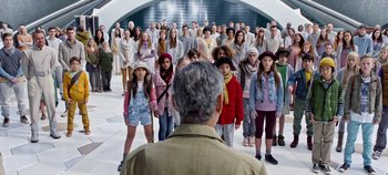 Movie still from “Tomorrowland” (2015), directed by Brad Bird – A group of people standing in front of an older man; Wide shot, High angle