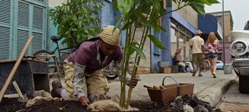 Movie still from “Tomorrowland” (2015), directed by Brad Bird – A woman kneeling down to plant a tree; Wide shot, Over the shoulder angle