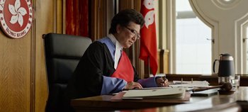 Movie still from “Tomorrowland” (2015), directed by Brad Bird – A woman sitting at a table in front of a laptop; Medium shot, Low angle